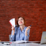 front-view-travel-agent-her-working-place-with-plane-tickets-agency-map-service-global-assistant-world-operator-managers (1)